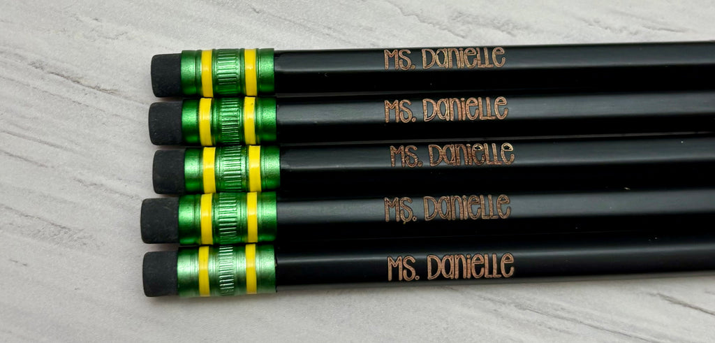 Five black pencils customized with a name.