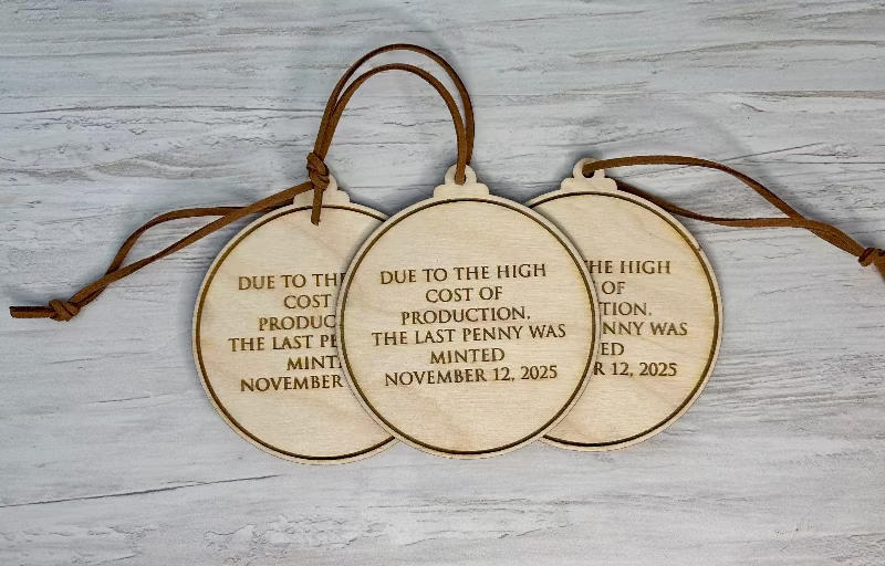 Back of historic penny ornament engraved with final penny minting date, wooden commemorative ornament honoring the end of the U.S. penny