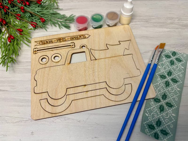 Ornament bar showing a truck with a tree in the back, paint pods, glue, paint brushes, and ribbon by Coastal Ginger Creations 