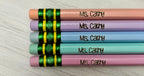 Five personalized pencils with pastel pink, purple, blue, green, and pink barrels, each engraved.